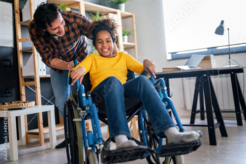 Happy multiethnic family with child with disability in wheelchair