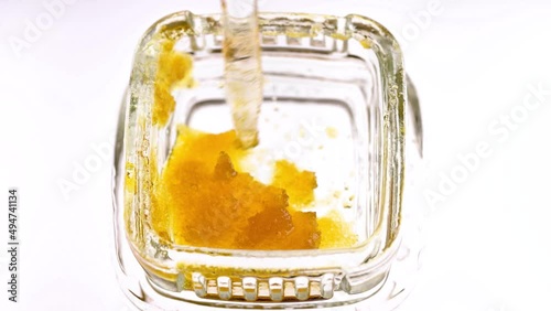 Macro view of marijuana concentrate wax in a small glass container.  