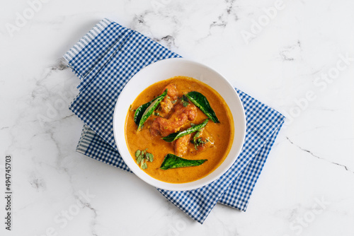 Goan Fish Curry masala in a basket isolated on napkin side view on grey background famous indian and pakistani food photo