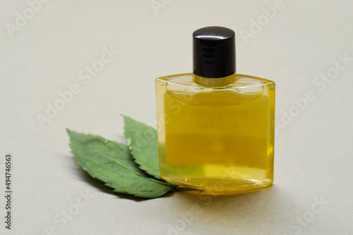 Bottle with orange gel and two leaves from wood on a craft background.