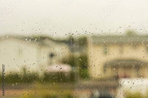 Close up view of raindrops on window pane with view from an apartment. Sweden.