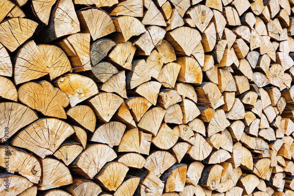 Stacked chopped wood close-up texture. Firewood storage background. Stocks of wooden logs. Chopping wood for a fireplace. Woodpile with firewood with visible wooden texture. Stacked chopped wood close-up texture. Firewood storage background. Stocks of wooden logs. Chopping wood for a fireplace. Woodpile with firewood with visible wooden texture.