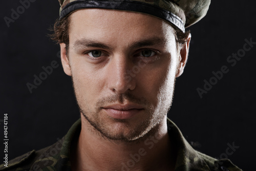 Stern soldier. Shot of a young man in military fatigues. photo