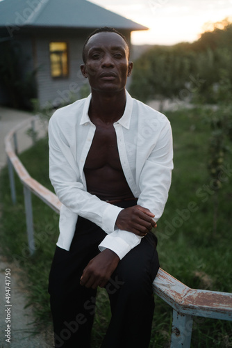 Portrait of a young South American man leaning on a fence on sunset