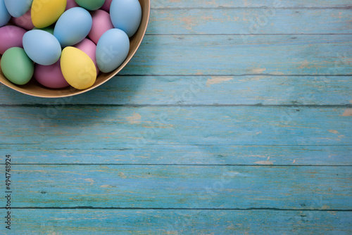 Easter eggs in a basket.. Easter eggs on wooden background. Copy space.