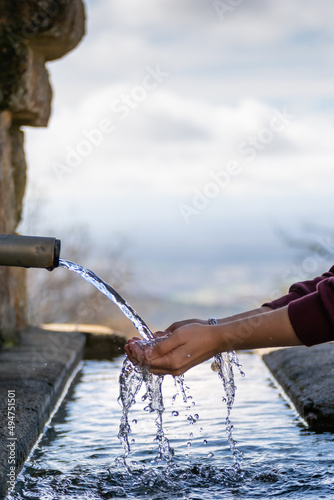 hands taking water from a fountain.