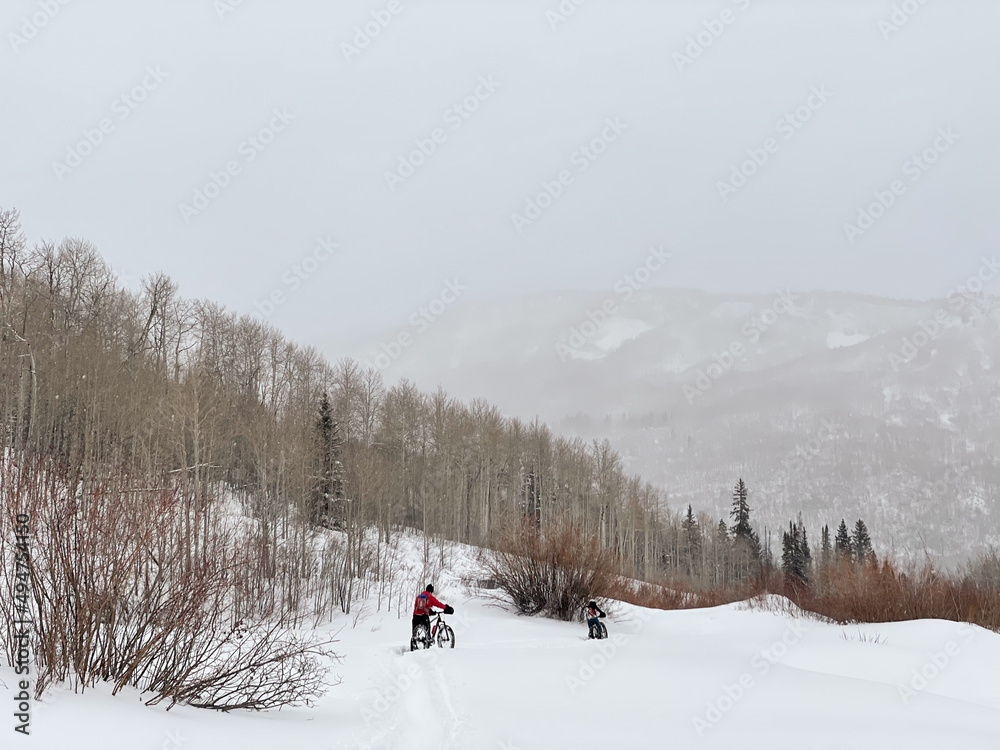 Two Mountain Bikers on a Snowy Trail