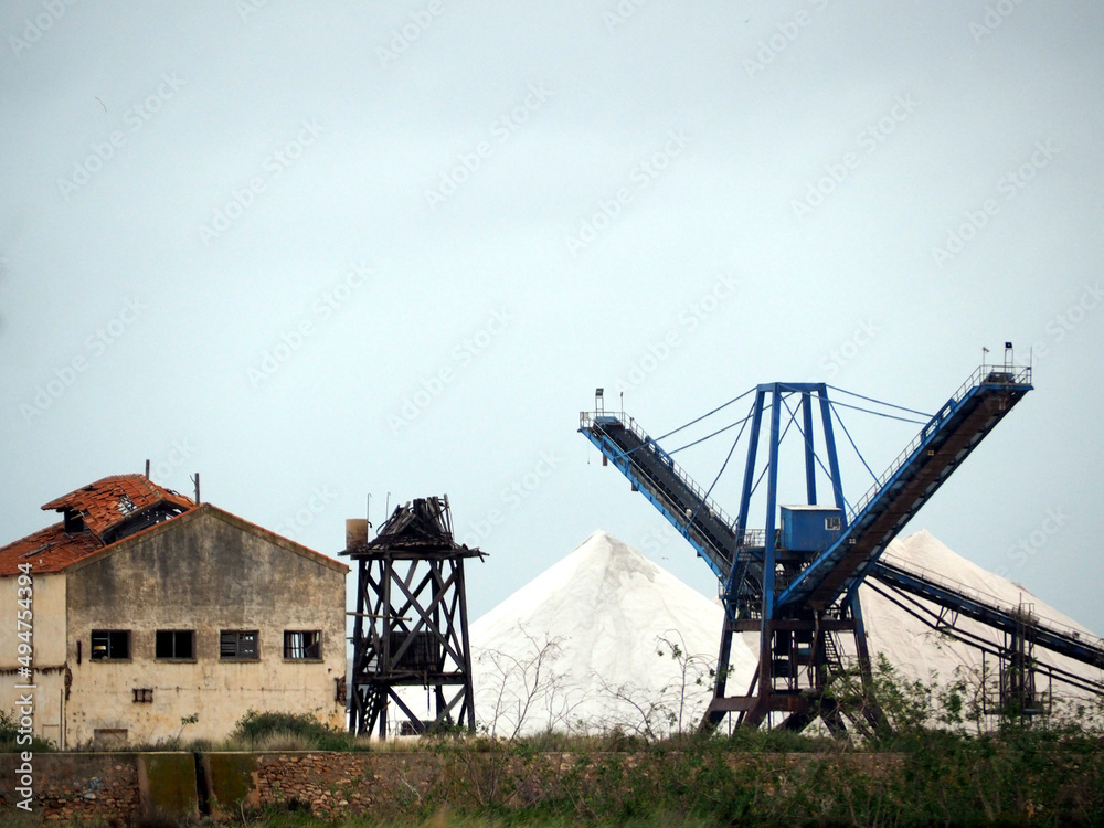 Sea salt mining facility, equipment and conveyor, mountains of sea salt