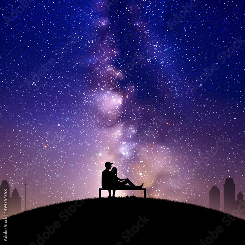 Lovers on bench in park. Loving couple silhouette at night. Milky Way