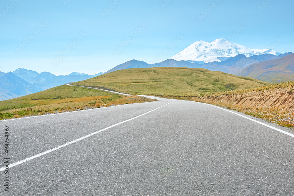 A winding mountain road to the Djily Su tract with beautiful views of the Elbrus peaks. Spring in the Caucasus.