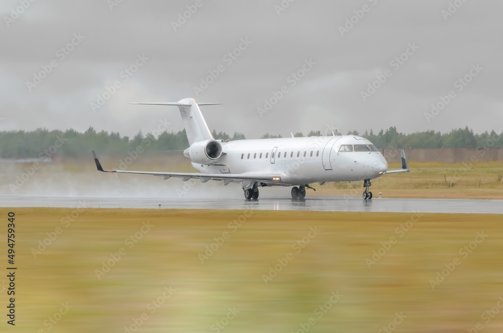 Small Airplane landing in a wet runway during the rain at the airport. Small Airplane landing in a wet runway during the rain at the airport.