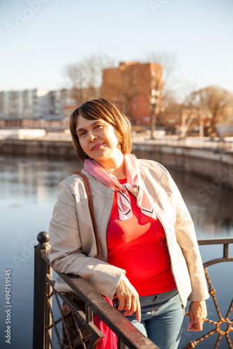 Contemplative casual senior woman looking away at embankment photo