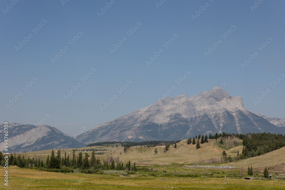 Landscape of snow-capped Crowsnest Mountain with beautiful summer skies