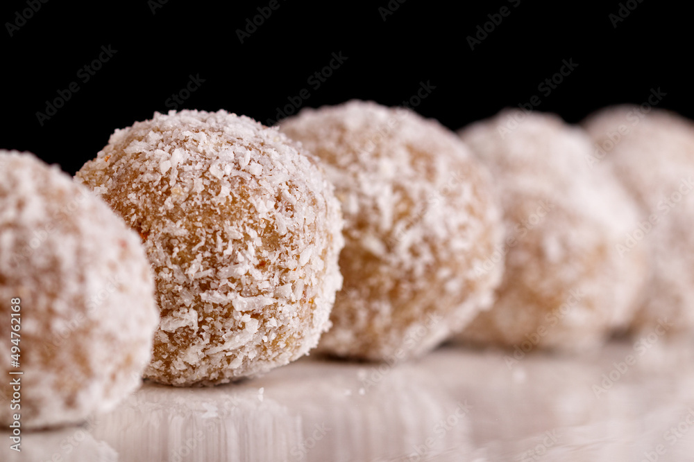 Beautiful sweets with coconut on a white plate on a black background Beautiful sweets with coconut on a white plate on a black background