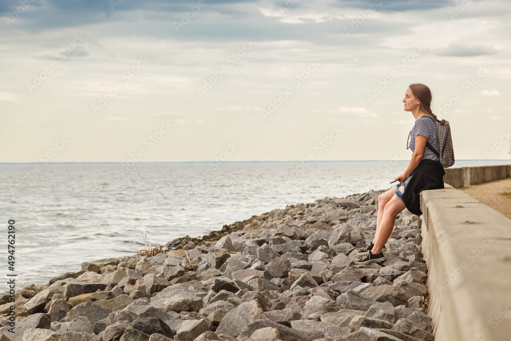 Beautiful girl on the sea with blue sky and clouds