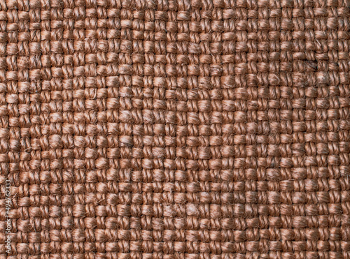 Close-up photo of burlap.. Sack texture background. Textile burlap background.  The texture of the fibers and threads of the coarse fabric. Textile abstraction. Textile brown background. 