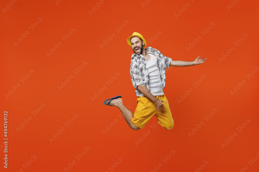 Full body excited fun musician singer young tourist man wear beach shirt hat do playing guitar gesture isolated on plain orange background studio portrait. Summer vacation sea rest sun tan concept Full body excited fun musician singer young tourist man wear beach shirt hat do playing guitar gesture isolated on plain orange background studio portrait. Summer vacation sea rest sun tan concept