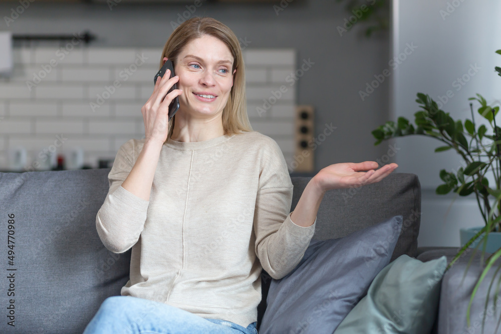 Happy woman at home, sitting on the couch and talking on the phone Happy woman at home, sitting on the couch and talking on the phone