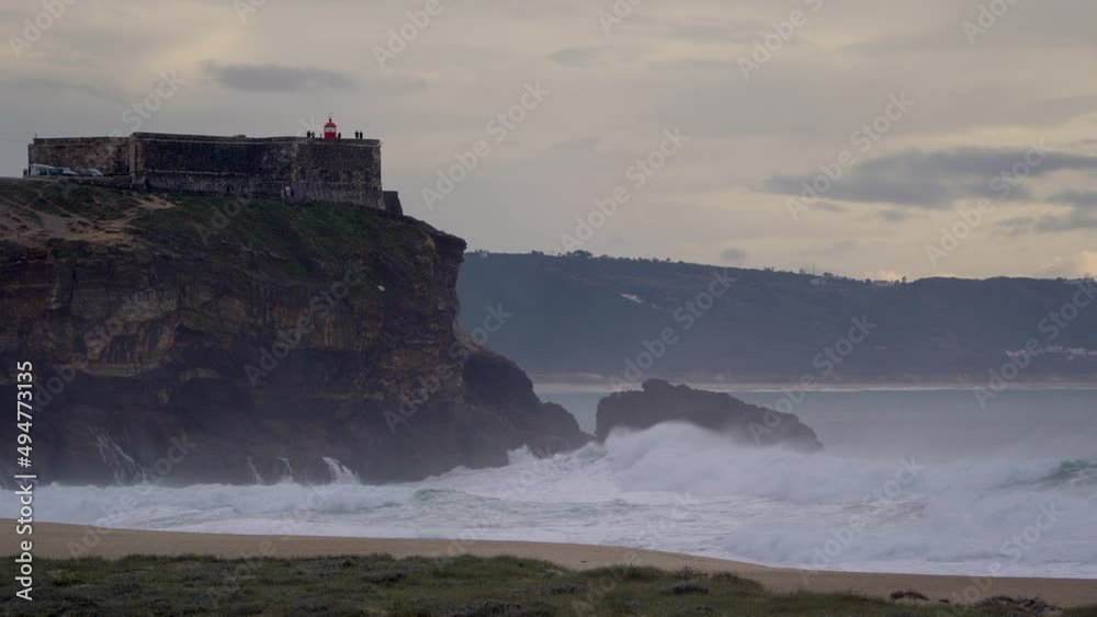 The coast of Nazaré in Portugal in the early evening with lighthouse The coast of Nazaré in Portugal in the early evening with lighthouse