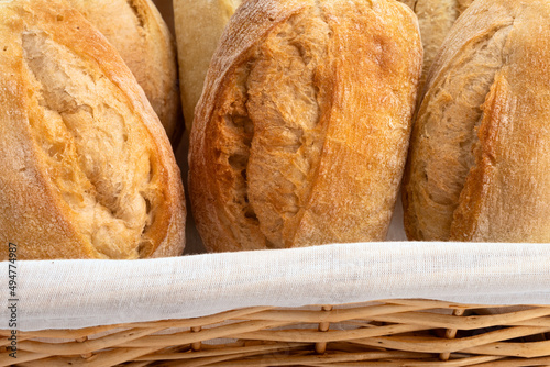 Close up of tasty baked wheat buns in a wicker basket