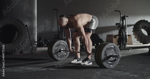 Furious sportsman doing deadlift attempt in gym photo