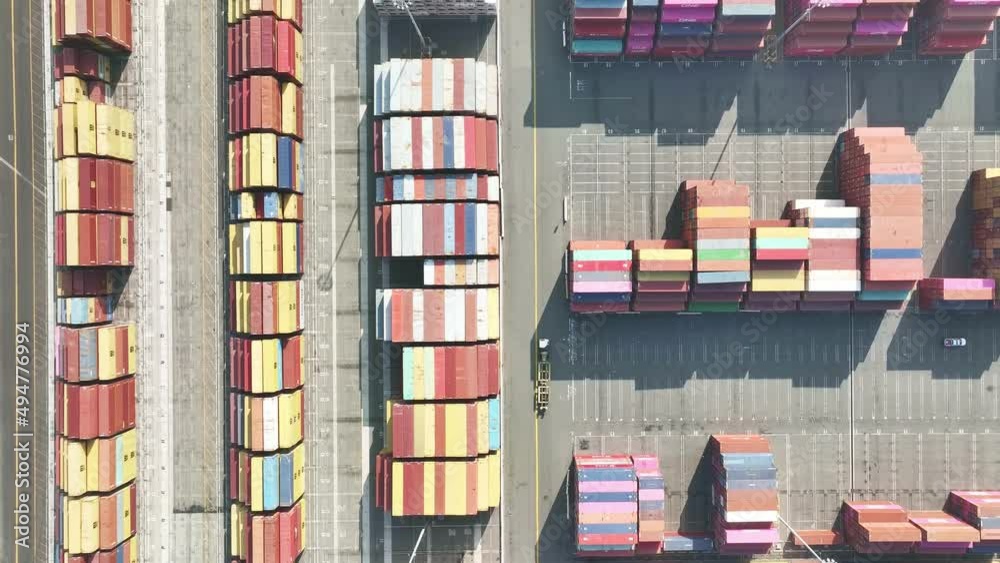 Drone shot, aerial view of semi truck and cranes lift cargo containers for international freight. Shipment from China to USA. Concept of global import export cargo. COVID vaccine shipment Drone shot, aerial view of semi truck and cranes lift cargo containers for international freight. Shipment from China to USA. Concept of global import export cargo. COVID vaccine shipment