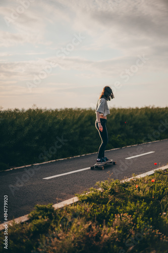 Girl rides a longboard and enjoying a free ride. Sunny day , poster, longboard day vertical banner