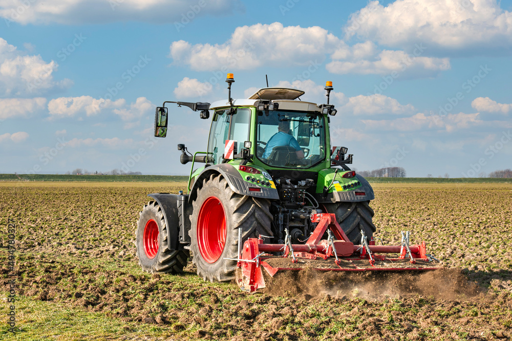 Fototapeta premium Tractor with cultivator working in the field | 5085