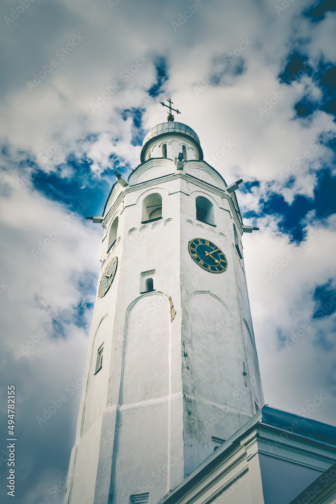The old clock tower Chasozvonya in the Kremlin of Veliky Novgorod against the cloudy blue sky