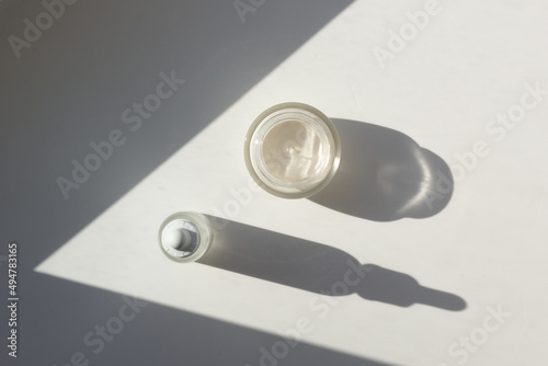 Obraz na płótnie Concept of minimalist skincare routine. Top down view serum and moisturizer with contrasting shadows. w salonie