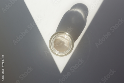 Obraz na płótnie Concept of minimalist skincare routine. Top down view of a moisturizer jar with contrasting shadows. w salonie