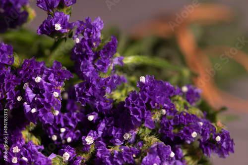 Focus on the foreground of a floral arrangement with limonium flowers bunch also known as sea-lavender. Natural composition for the celebration of spring or Easter card.