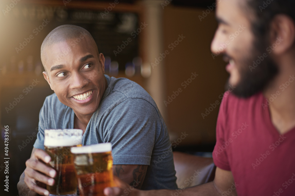 Heres to the weekend. Shot of two friends enjoying themselves in the pub.