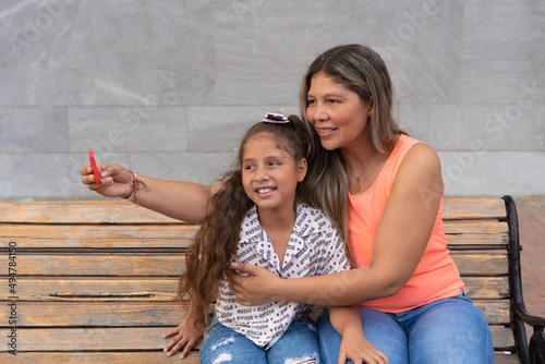 Smiling mother and daughter bonding together to take a selfie