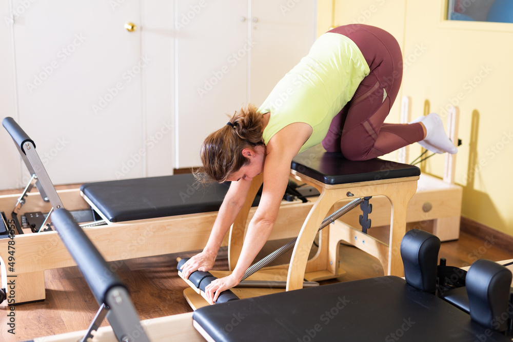 Gym woman pilates stretching sport in reformer bed