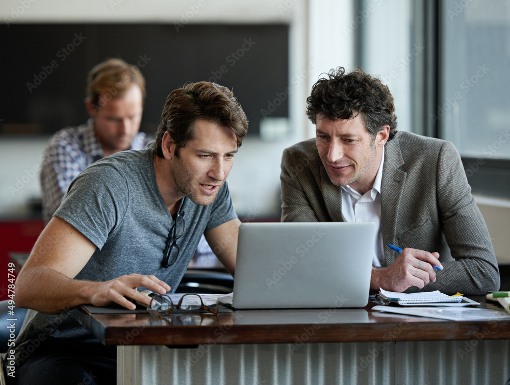 This is very interesting. Shot of two male colleagues talking together over a laptop. This is very interesting. Shot of two male colleagues talking together over a laptop.