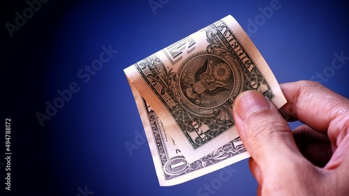 Businessman's hand holding American Dollar Banknotes, isolated on black background. Business Investment Economy Saving Loan Income Money and Finance concept. One Dollar, 1 USD. Prosperity concept.