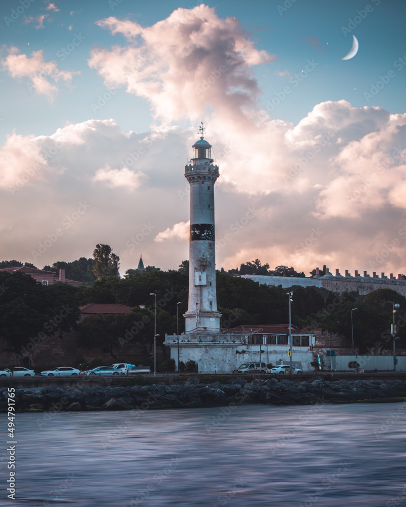 Panoramic photo taken from the river of Ahırkapı Fog Horn and Lighthouse backlit at sunset in Istanbul Turkey