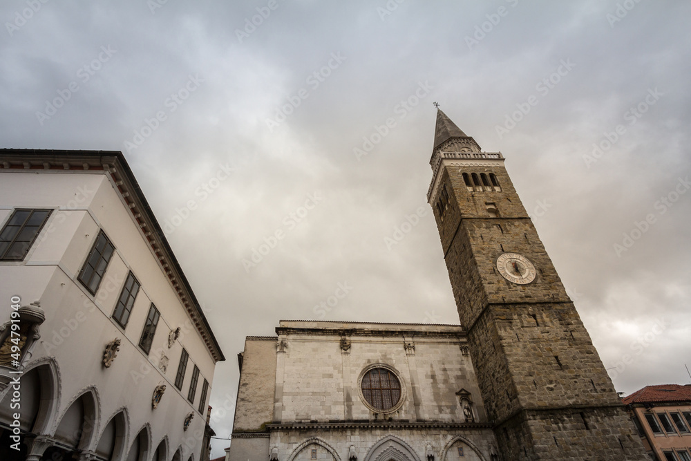 Panorama of the Titov trg square in Koper, Slovenia during a cloudy afternoon, with the Mestni Stolp city tower, cathedral of the assumption and praetorian palace. koper is a slovenian town of istria