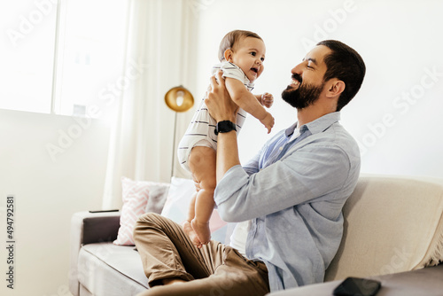 Father and his baby son playing at home