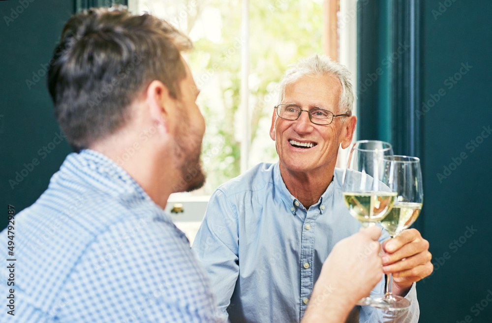 Heres to you and me dad. Shot of a cheerful elderly man and his son sharing a celebratory toast with wine glasses at home. Heres to you and me dad. Shot of a cheerful elderly man and his son sharing a celebratory toast with wine glasses at home.