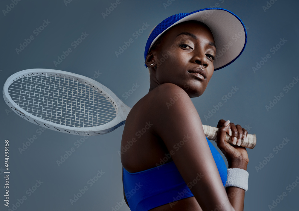 Get up and make it happen. Studio shot of a sporty young woman posing with a tennis racket against a grey background. - obrazy, fototapety, plakaty 