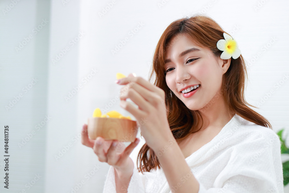 Beautiful Asian girl doing spa at home Holding a golden silk cocoon to scrub the face. Help nourish the skin to look young and healthy. beauty concept. copy space Beautiful Asian girl doing spa at home Holding a golden silk cocoon to scrub the face. Help nourish the skin to look young and healthy. beauty concept. copy space