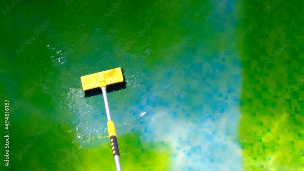 Pool Cleaning.Man brushing a swimming pool.Algae in the pool. Cleaning