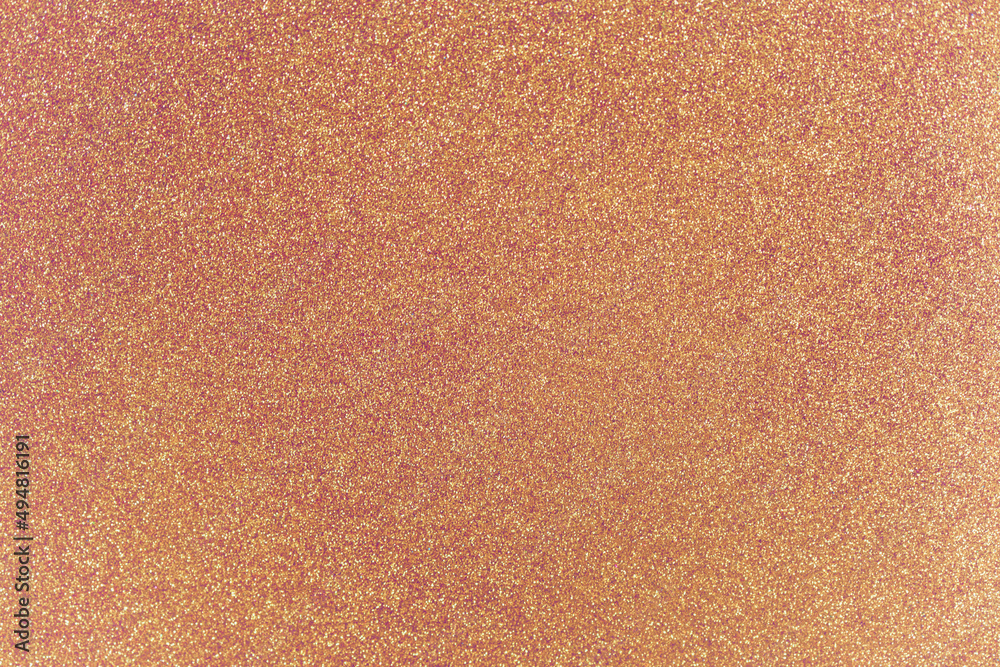 Fototapeta premium Golden rose glitter twinkle abstract festive Christmas or summer holidays background with sparkles. Modern luxury mock up with sequins. Texture of colored porous rubber with spangles