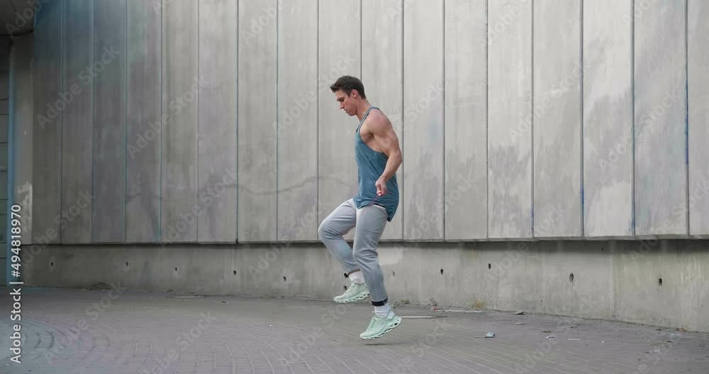 Athletic shirtless man training jump exercise on skipping rope on workout. Sporty man jumping with jumping rope. Young man training cardio exercises