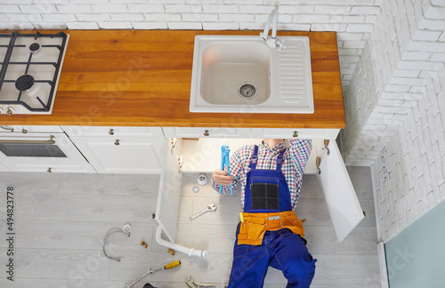 Obraz na plátně Plumber working in a modern kitchen