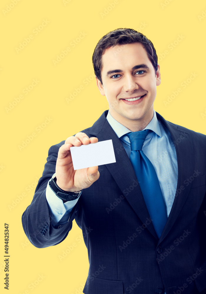 Middle aged businessman showing empty white mock up credit card with copy space area, over yellow color background. Portrait of happy smiling confident business man at studio. Middle aged businessman showing empty white mock up credit card with copy space area, over yellow color background. Portrait of happy smiling confident business man at studio.