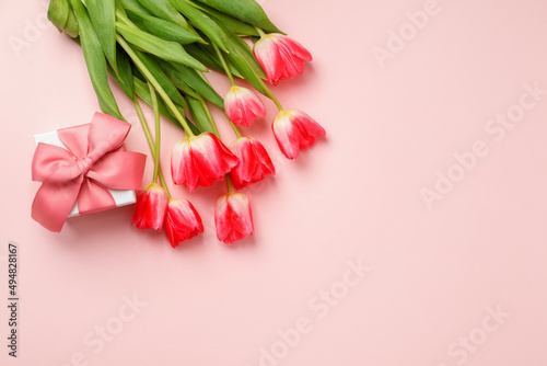 Beautiful spring surprise on Mothers or Womans International day 8 march. Bouquet of pink tulips, gift box on pink table top view. Flat lay, stylish banner for site, seasonal flyer