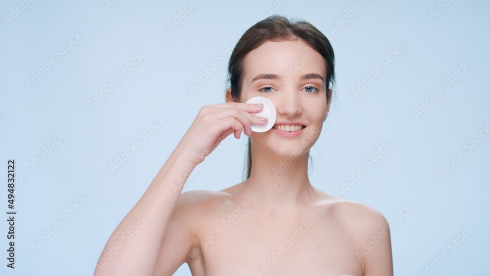 Close-up beauty portrait of young brunette woman uses a cotton pad to clean her face | Skin cleansing product commercial concept Close-up beauty portrait of young brunette woman uses a cotton pad to clean her face | Skin cleansing product commercial concept